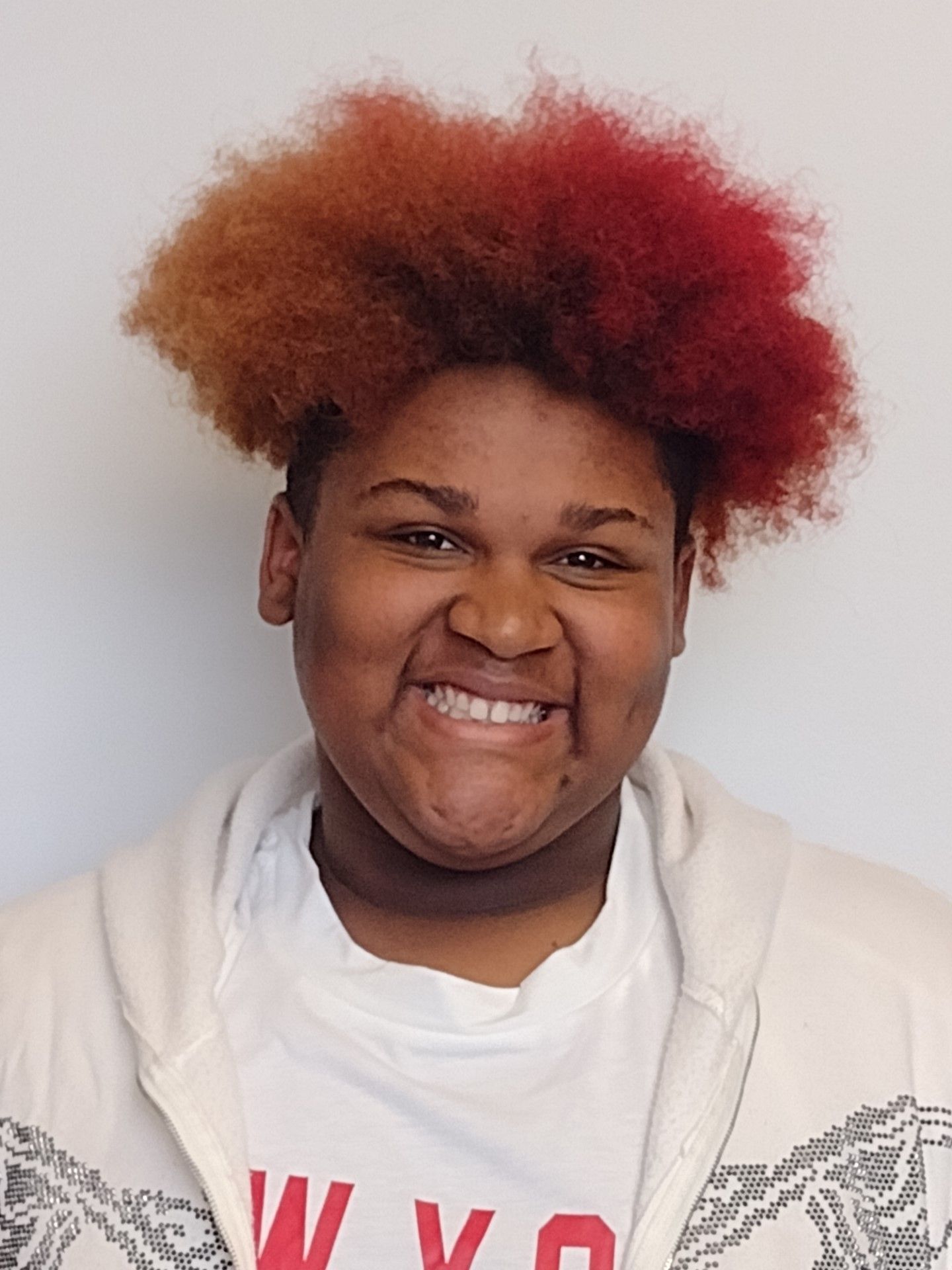 A young man with red hair is smiling for the camera.