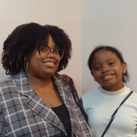 A woman and a girl are posing for a picture and smiling