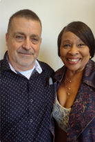 A man and a woman are posing for a picture together and smiling.