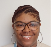 A woman wearing glasses and hoop earrings is smiling for the camera.