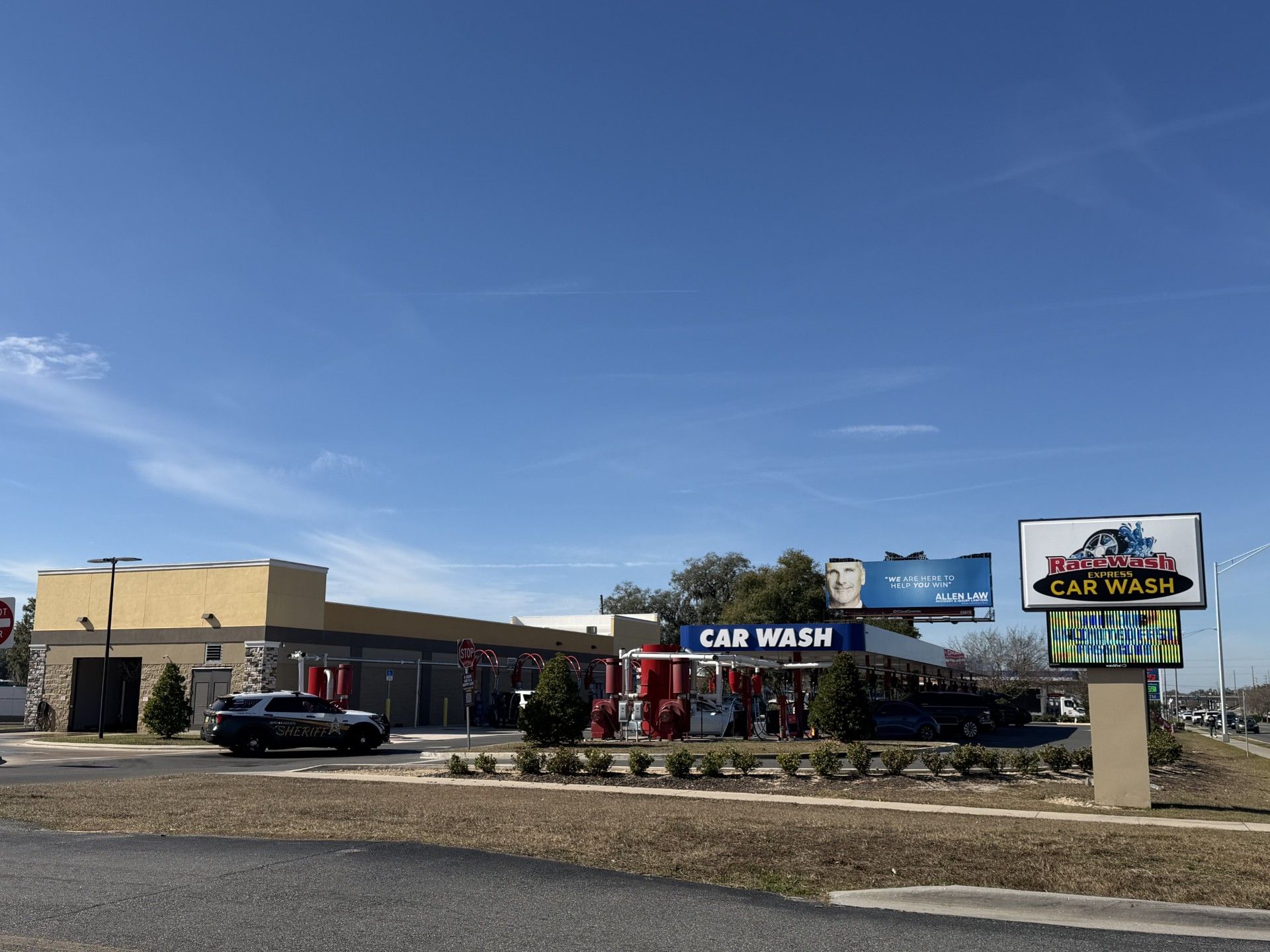 Car wash with a building and entry/exit lanes on a sunny day.