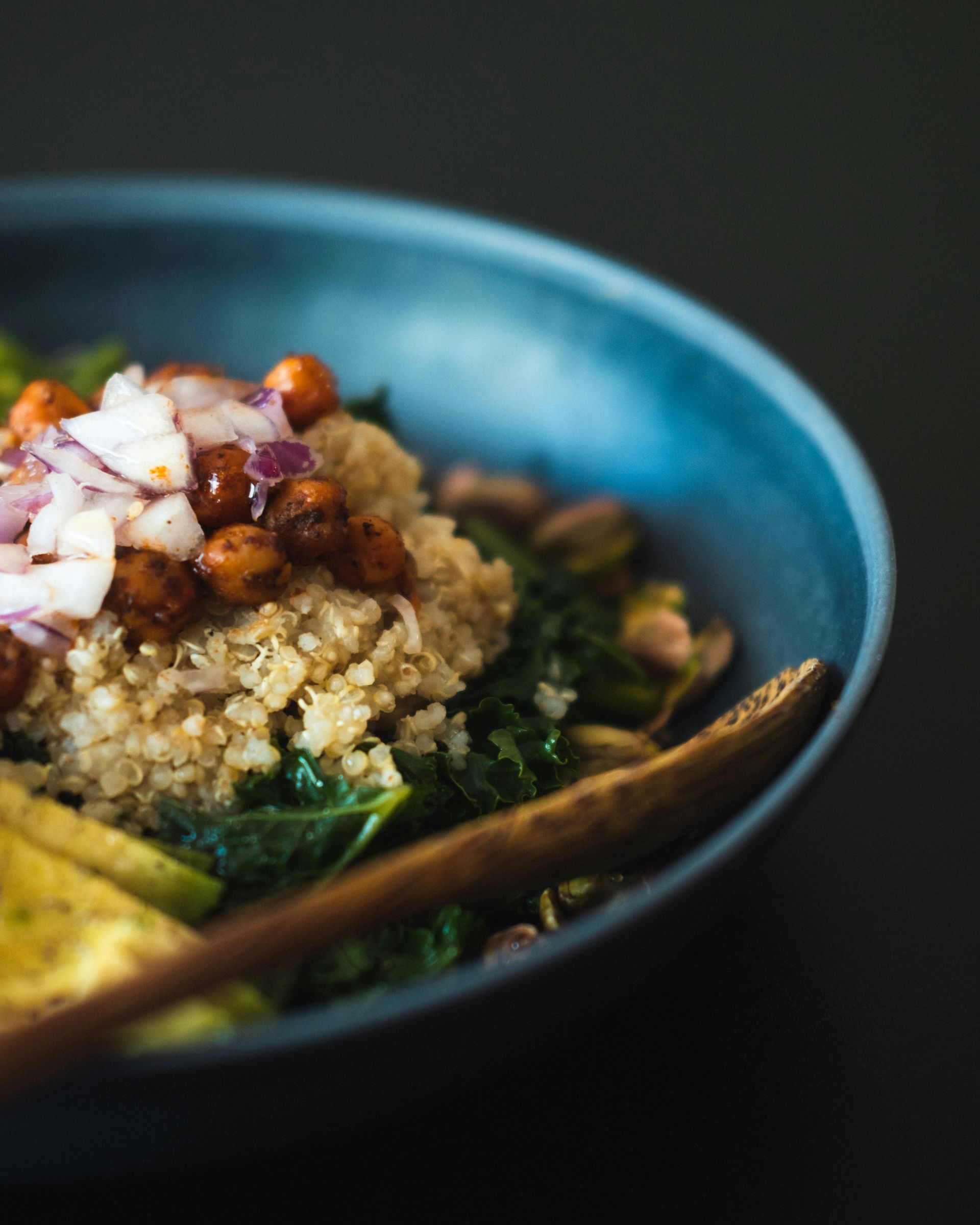 A close up of a bowl of food with a wooden spoon in it.