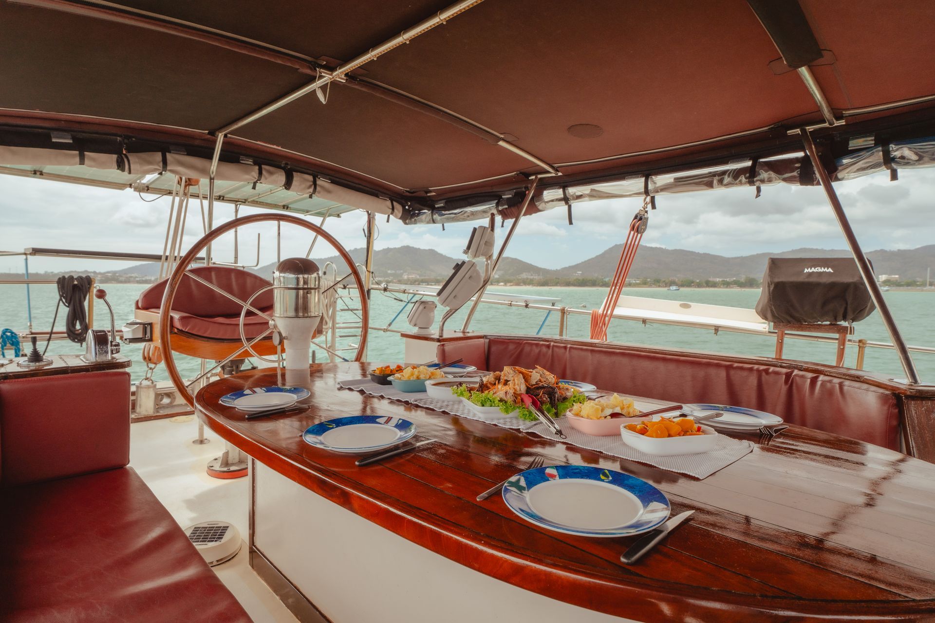 There is a table with plates of food on it on a schooner.