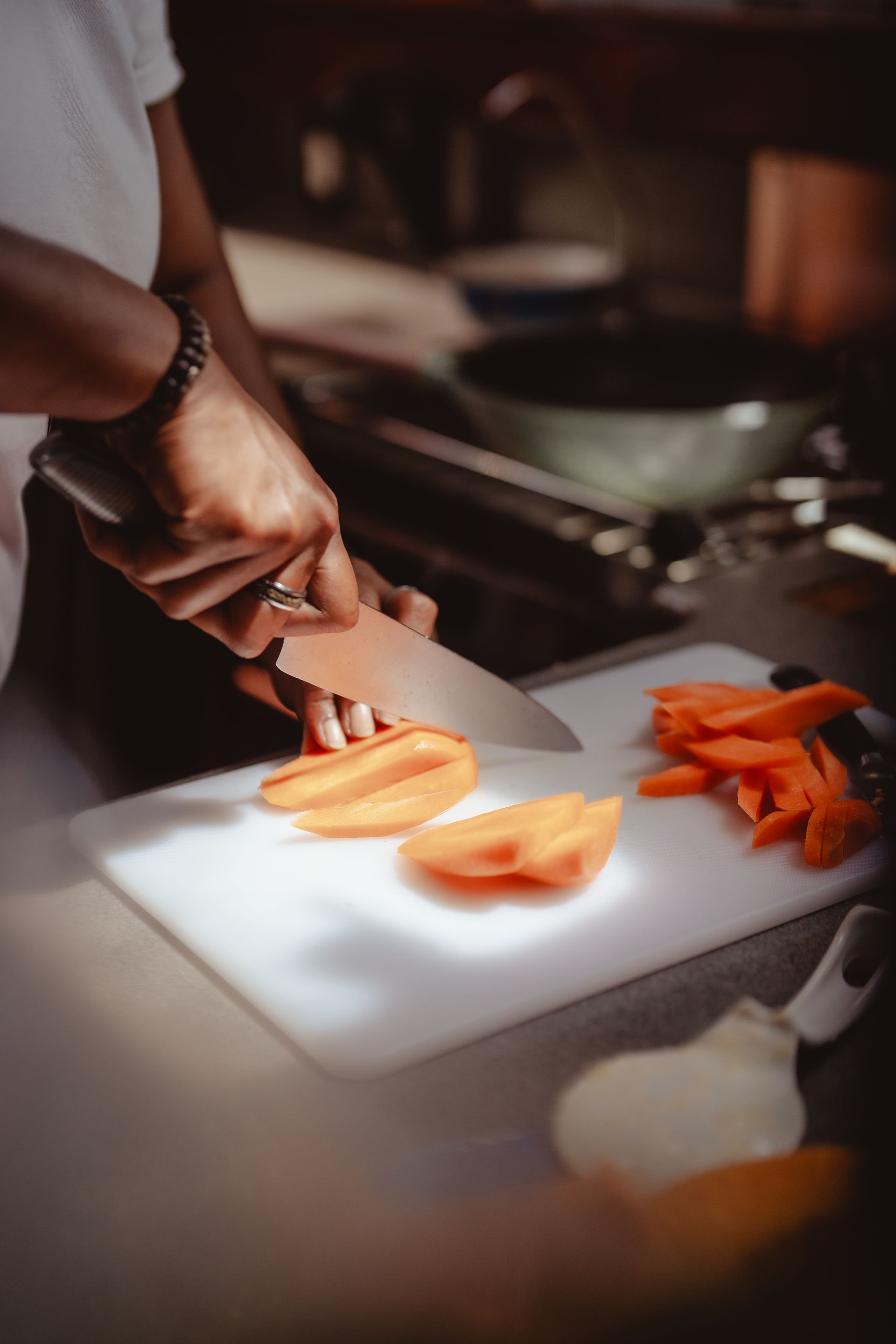 A person is cutting carrots on a cutting board in sailing boat. 
