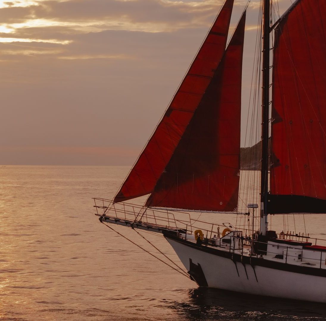 A sailboat with red sails in the ocean
