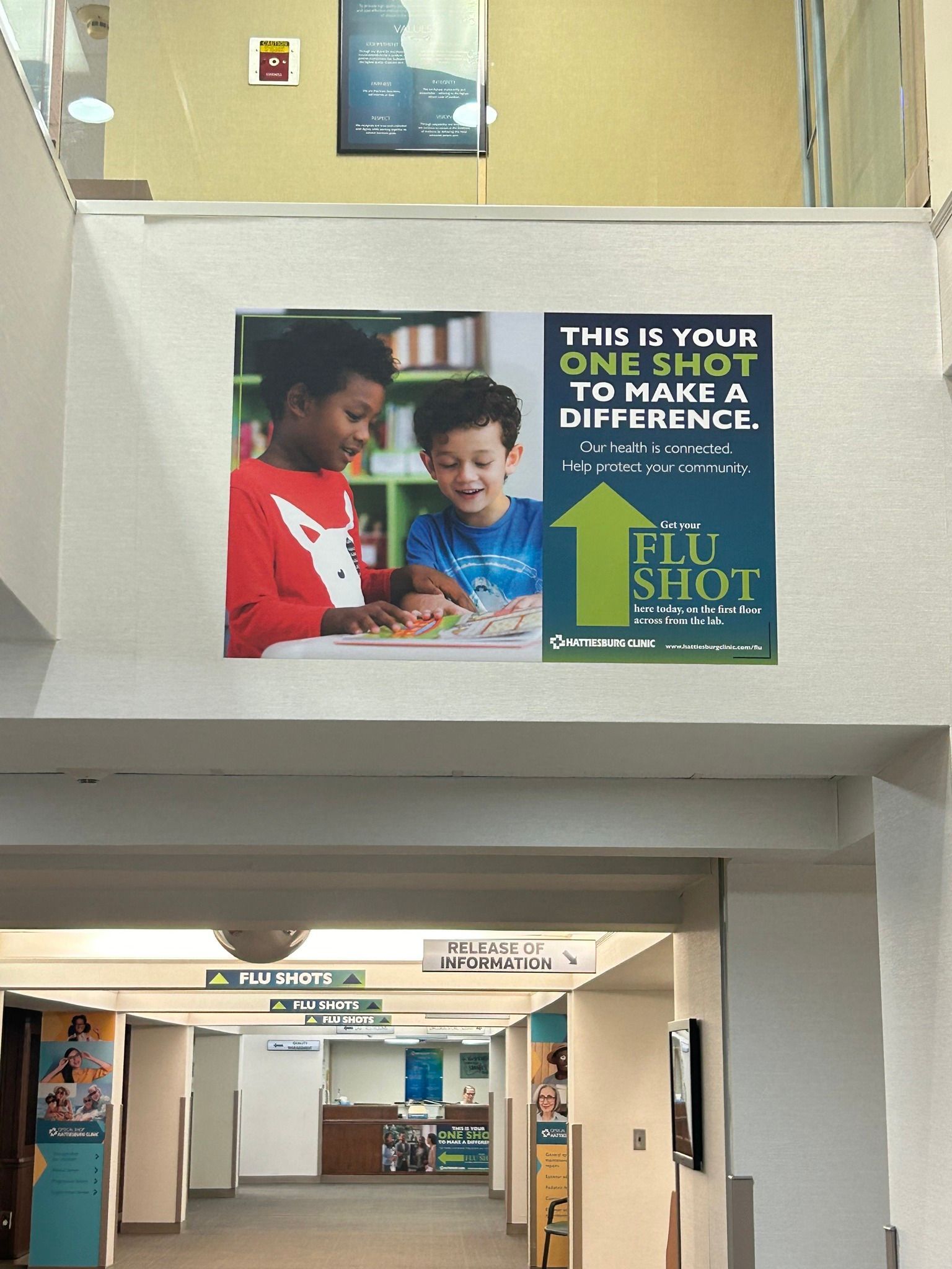 A wall sign promoting flu shots, featuring an upward green arrow and the text 