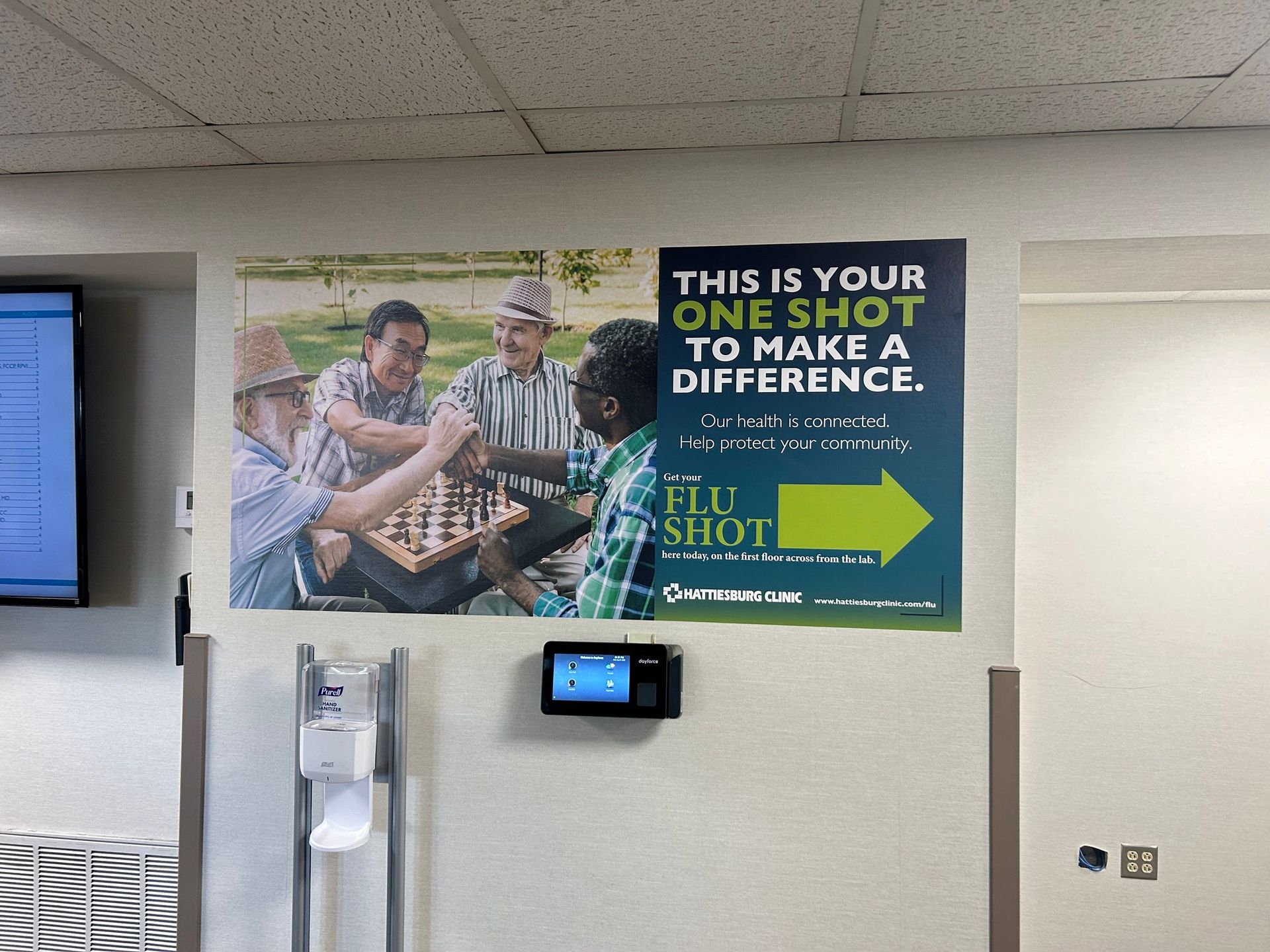 A poster on a wall promoting flu shots, featuring a group of people playing chess and the slogan 