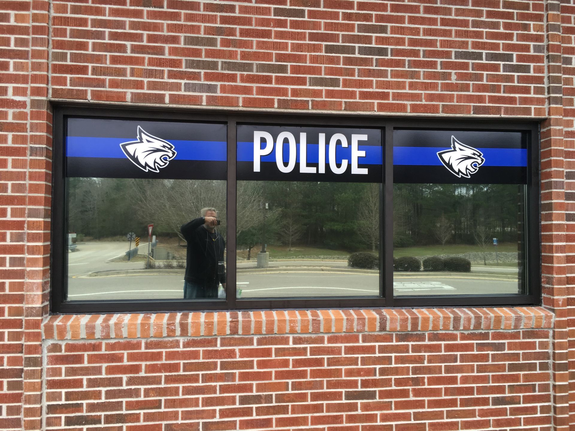 A brick building exterior with a window displaying 