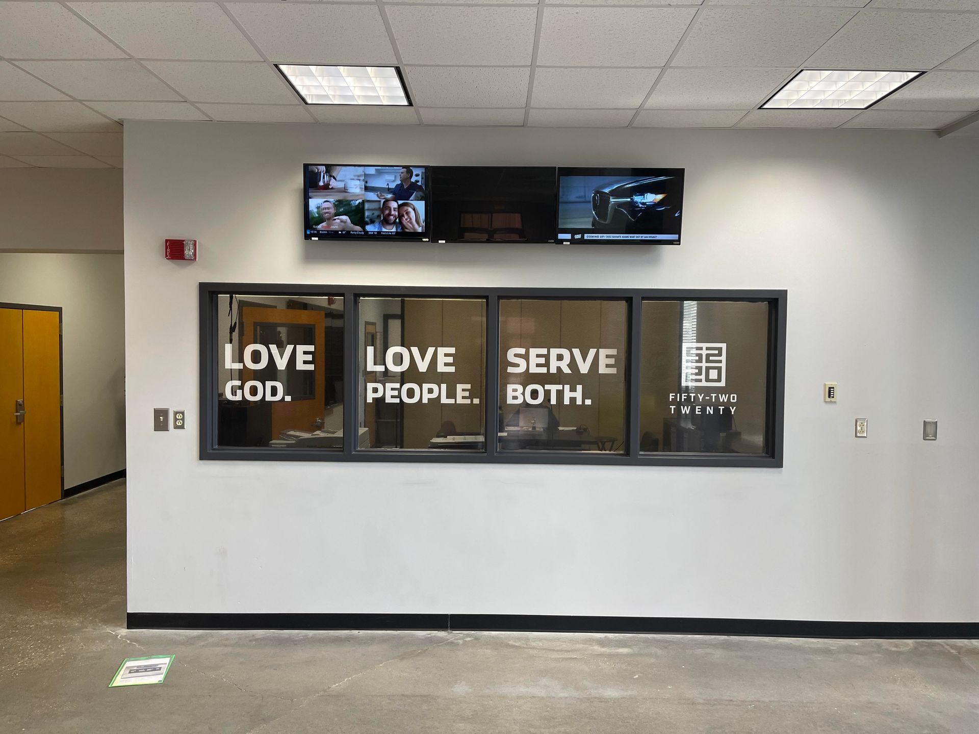 A wall with a multi-pane window displaying the text 