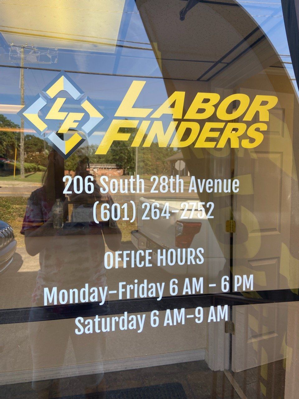 A Labor Finders office door with its address (206 South 28th Avenue), phone number (601) 264-2752, and office hours.
