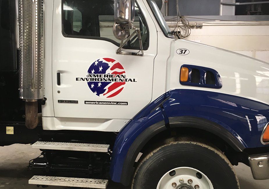 A white truck side panel featuring a logo with an American flag circular design and the text 