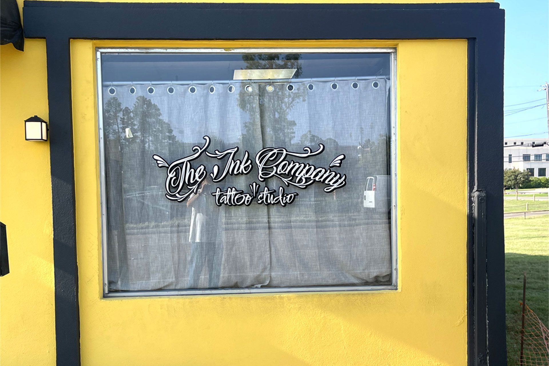 A yellow-walled building exterior featuring a window with a sign that reads 