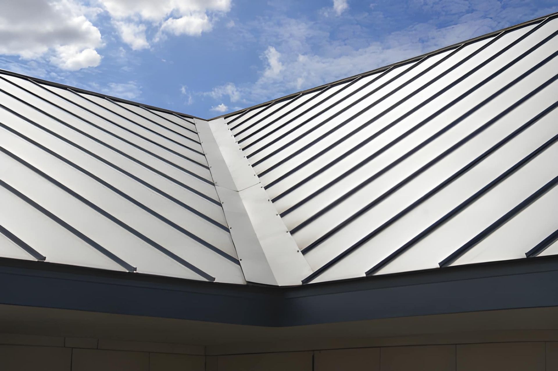 Metal roof against a partly cloudy blue sky.
