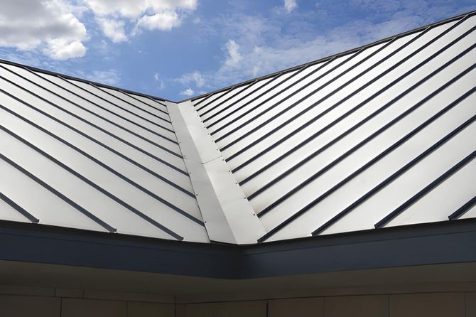 Metal roof against a partly cloudy blue sky.