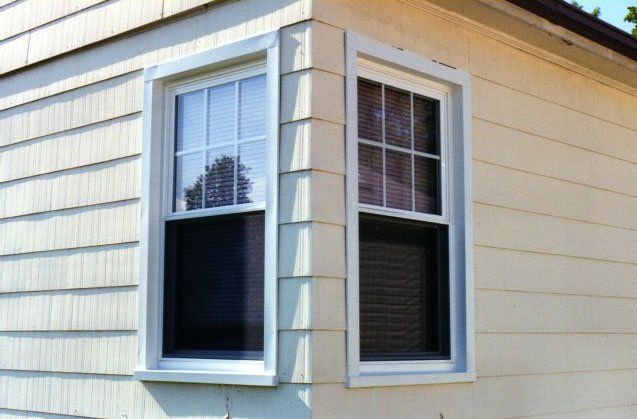 Two sliding windows on a corner of a yellow home Grand Island, NY