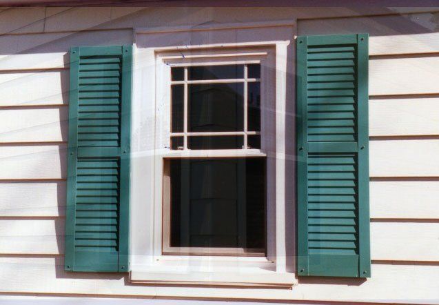 Sliding window with etched glass details and green shutters Kenmore, NY