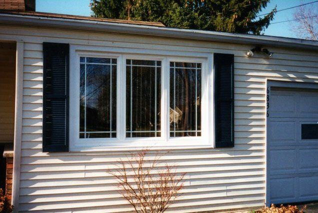 Triple window set with etched glass markings along a white trim Amherst, NY