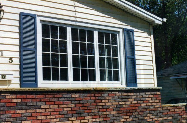 Triple sliding casement windows installed in a brick and vinyl sided home Kenmore, NY