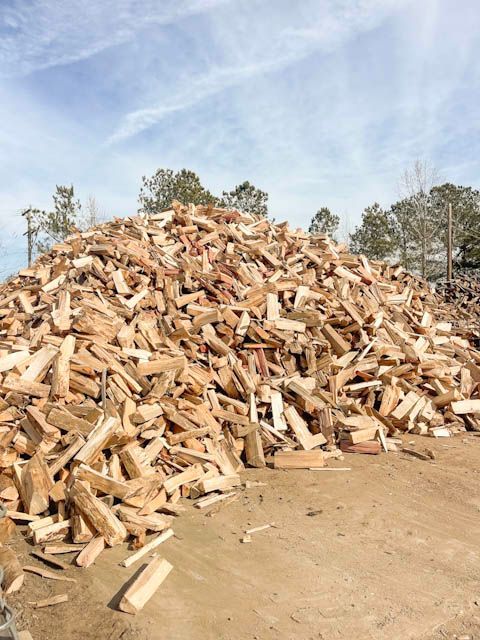 a truck is carrying a large pile of wood .