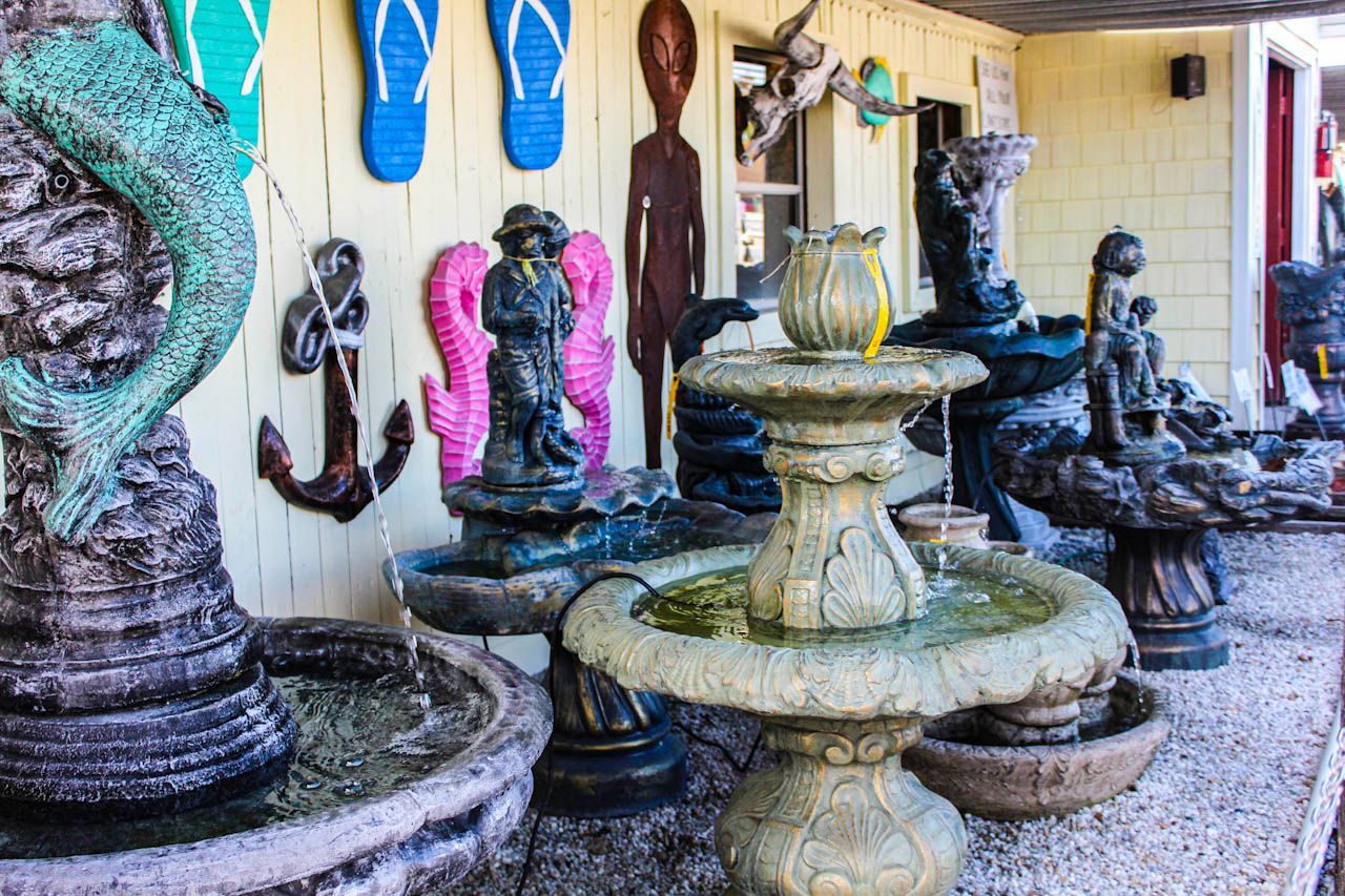 a large fountain is sitting on the ground next to a fence .
