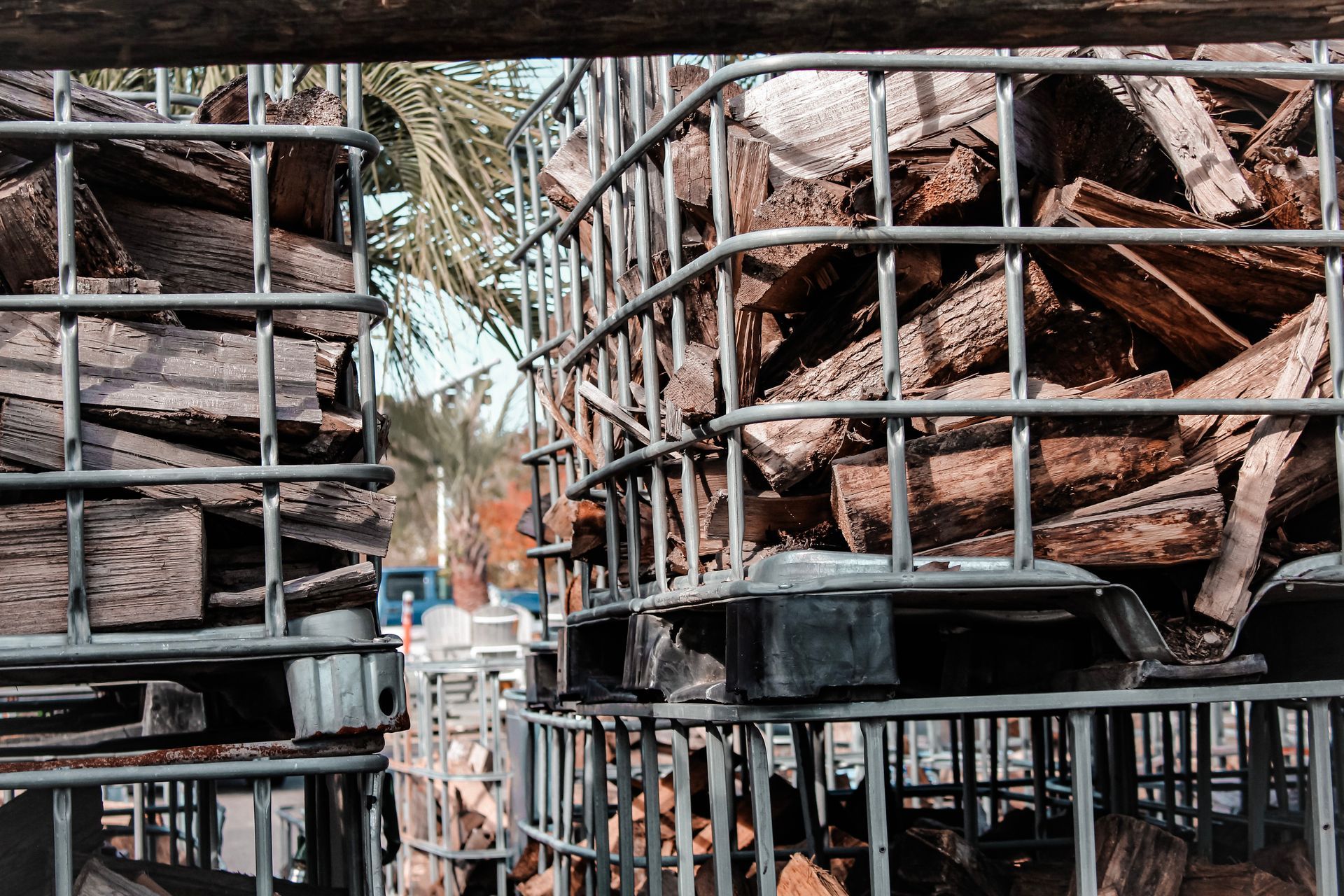 a pile of wood is sitting in a metal cage .