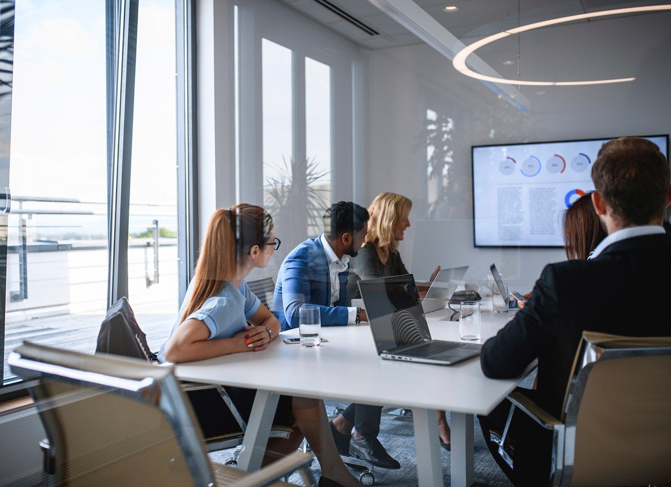 A group of people are sitting at a table in a conference room.