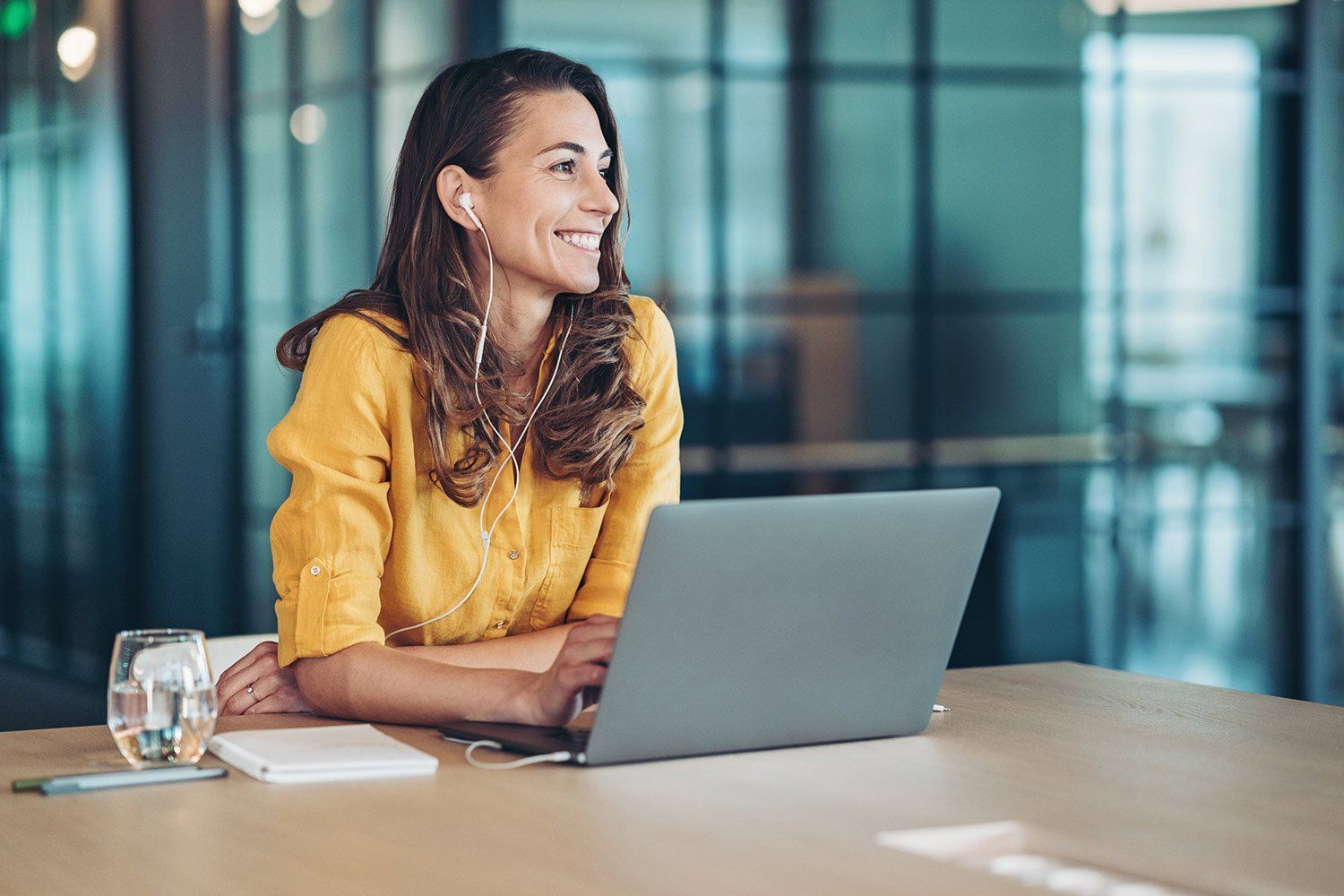 A woman is sitting at a table using a laptop computer.