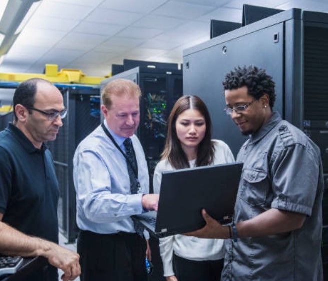 A man and a woman are looking at a tablet in a server room.