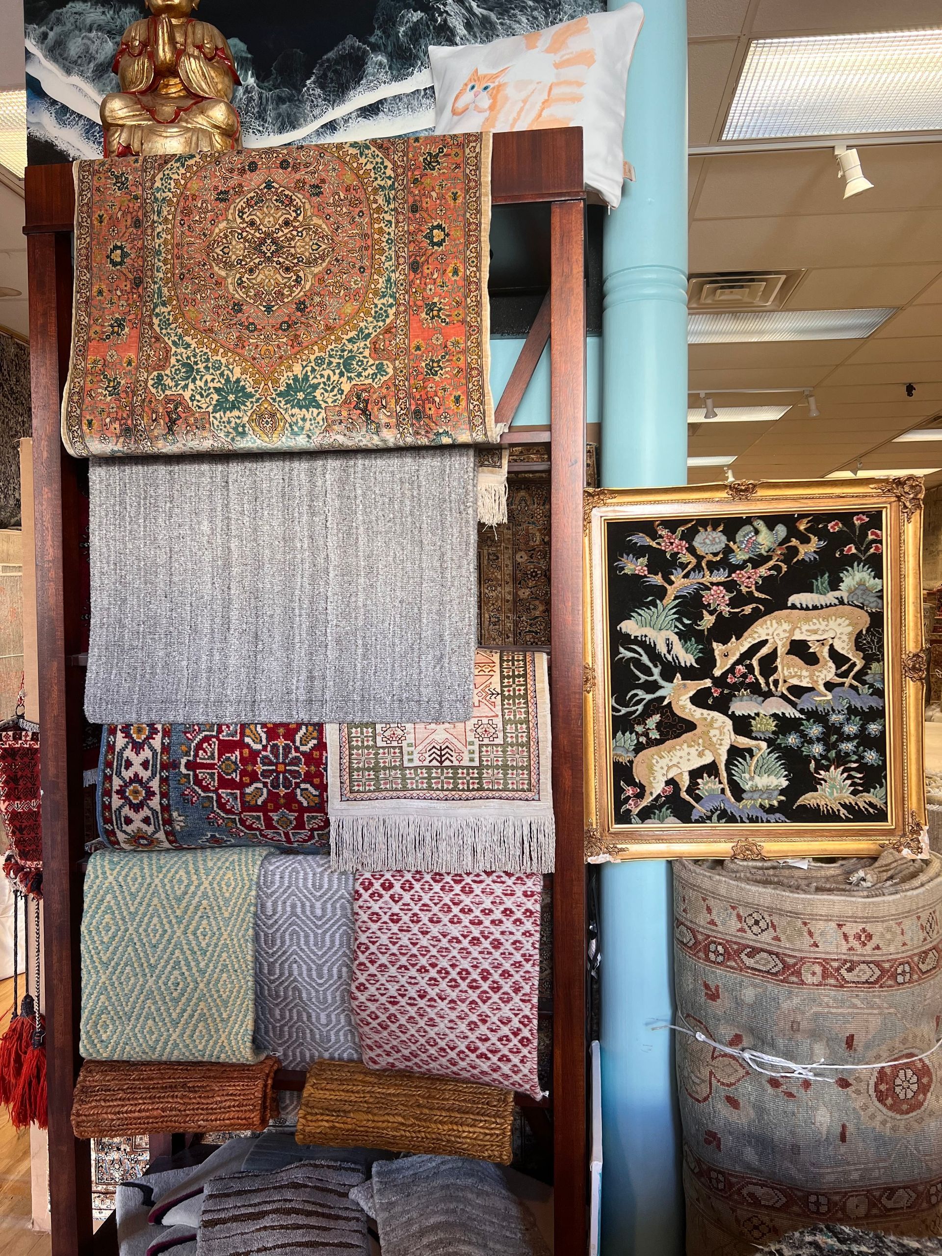 A shelf filled with a variety of rugs and pillows in a store.