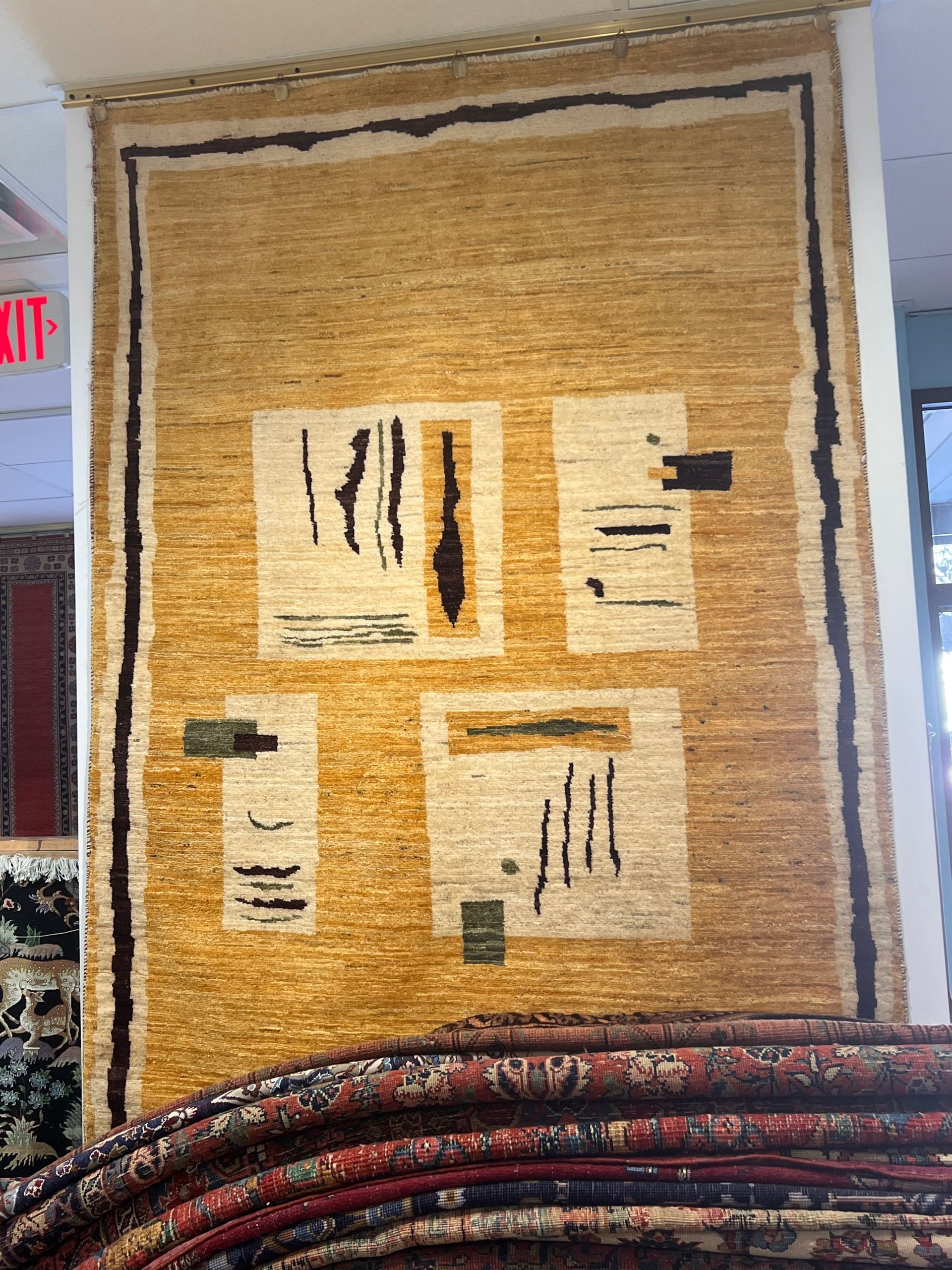 A large rug is hanging on a wall in a store.