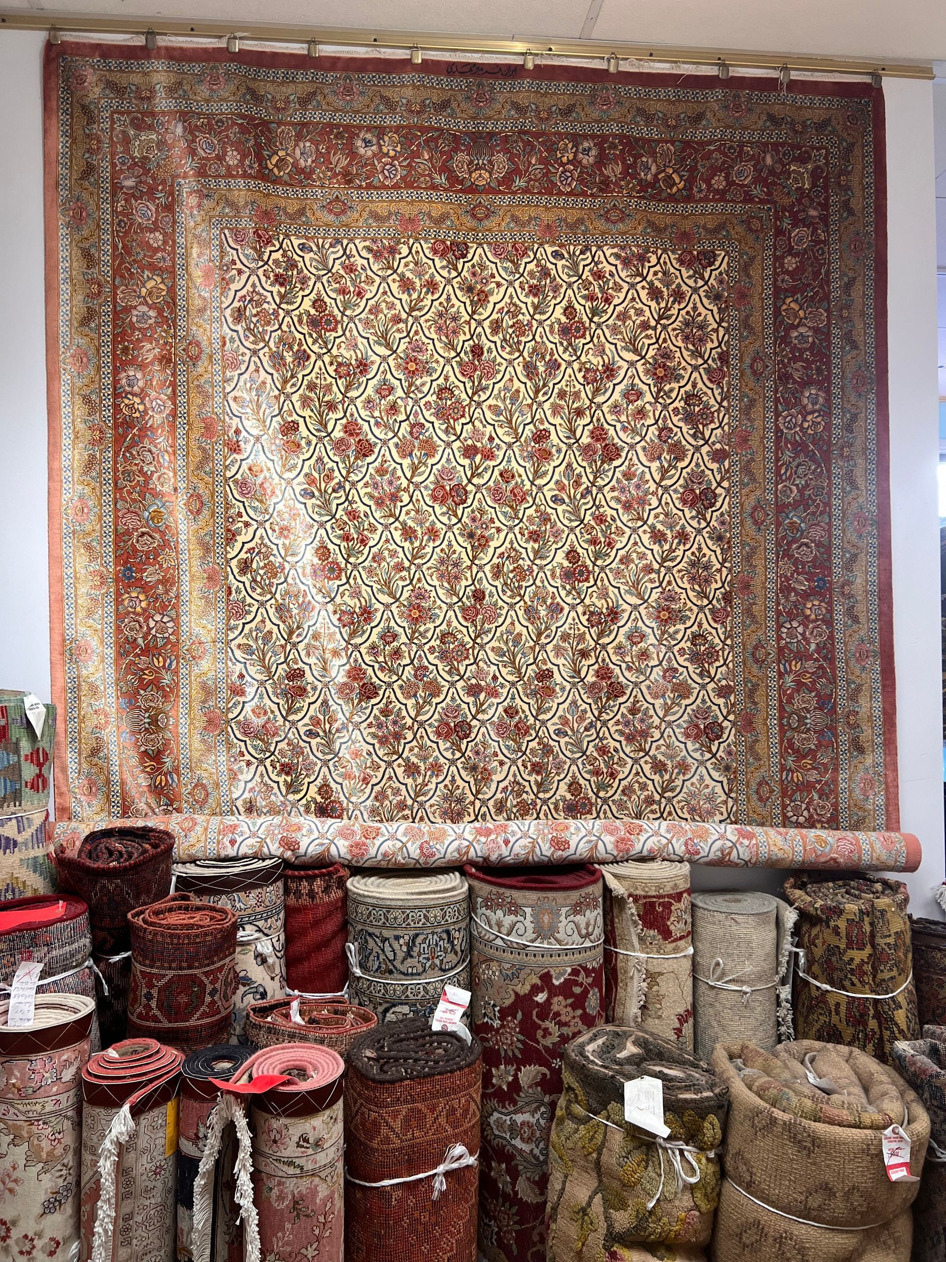 A large rug is hanging on a wall in a store.