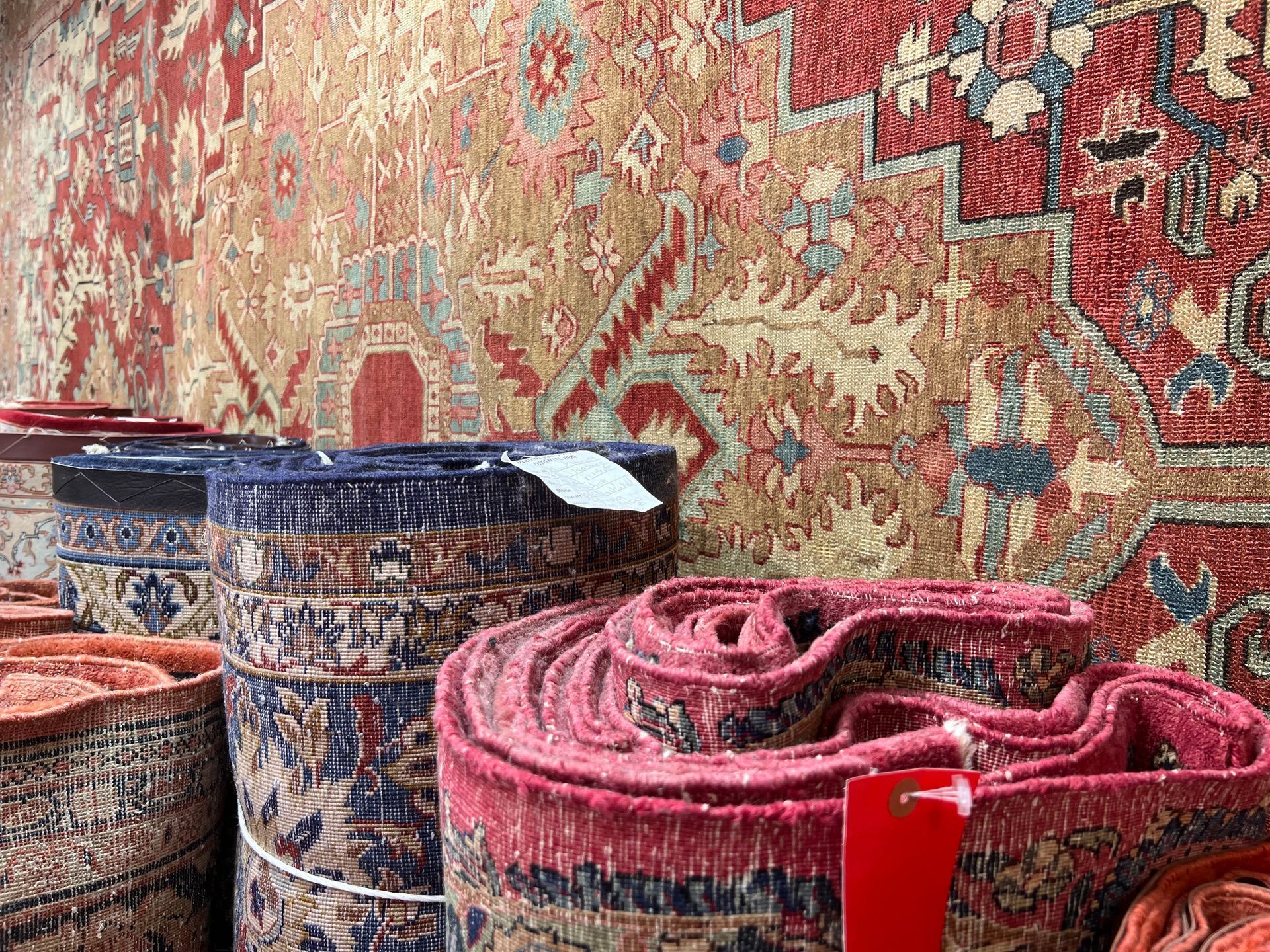 A bunch of rugs are stacked on top of each other on a table.