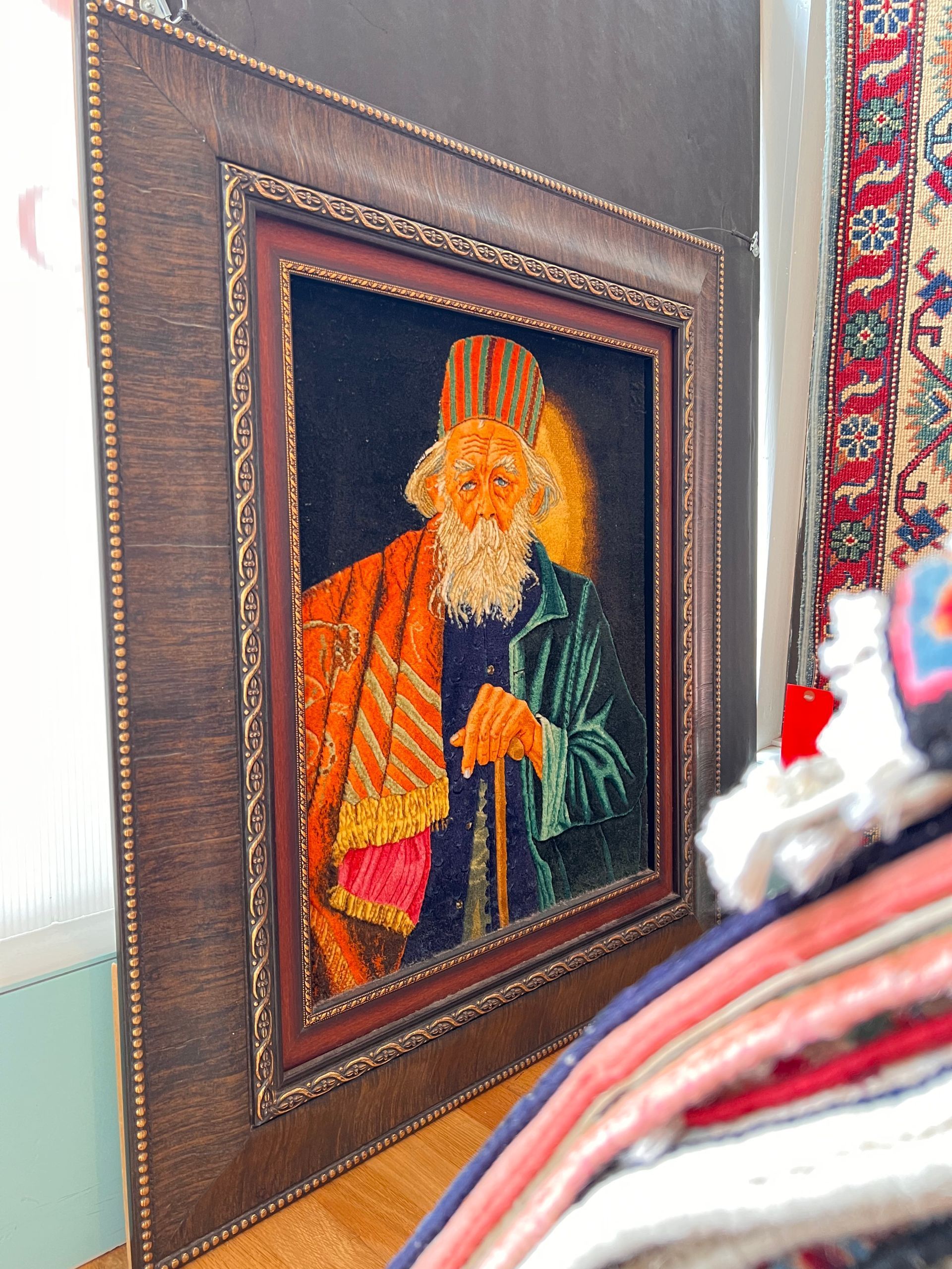 A framed painting of an old man with a cane