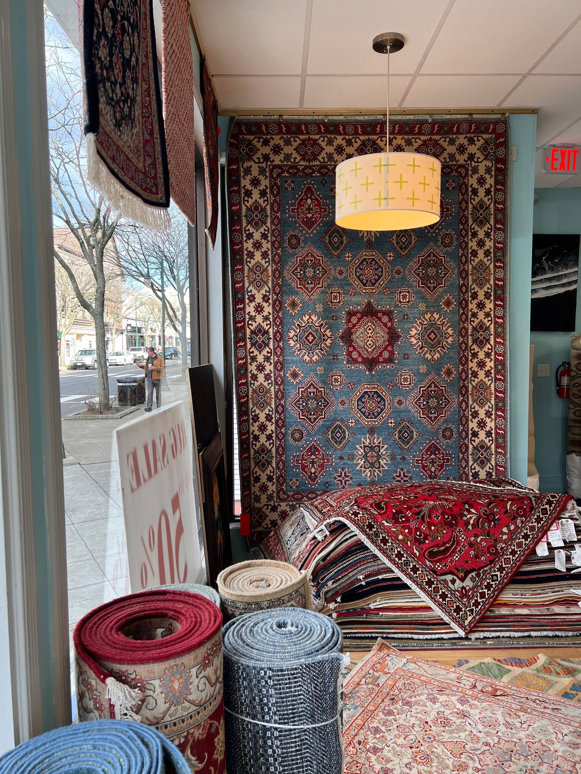 A room filled with lots of rugs and a ceiling light.