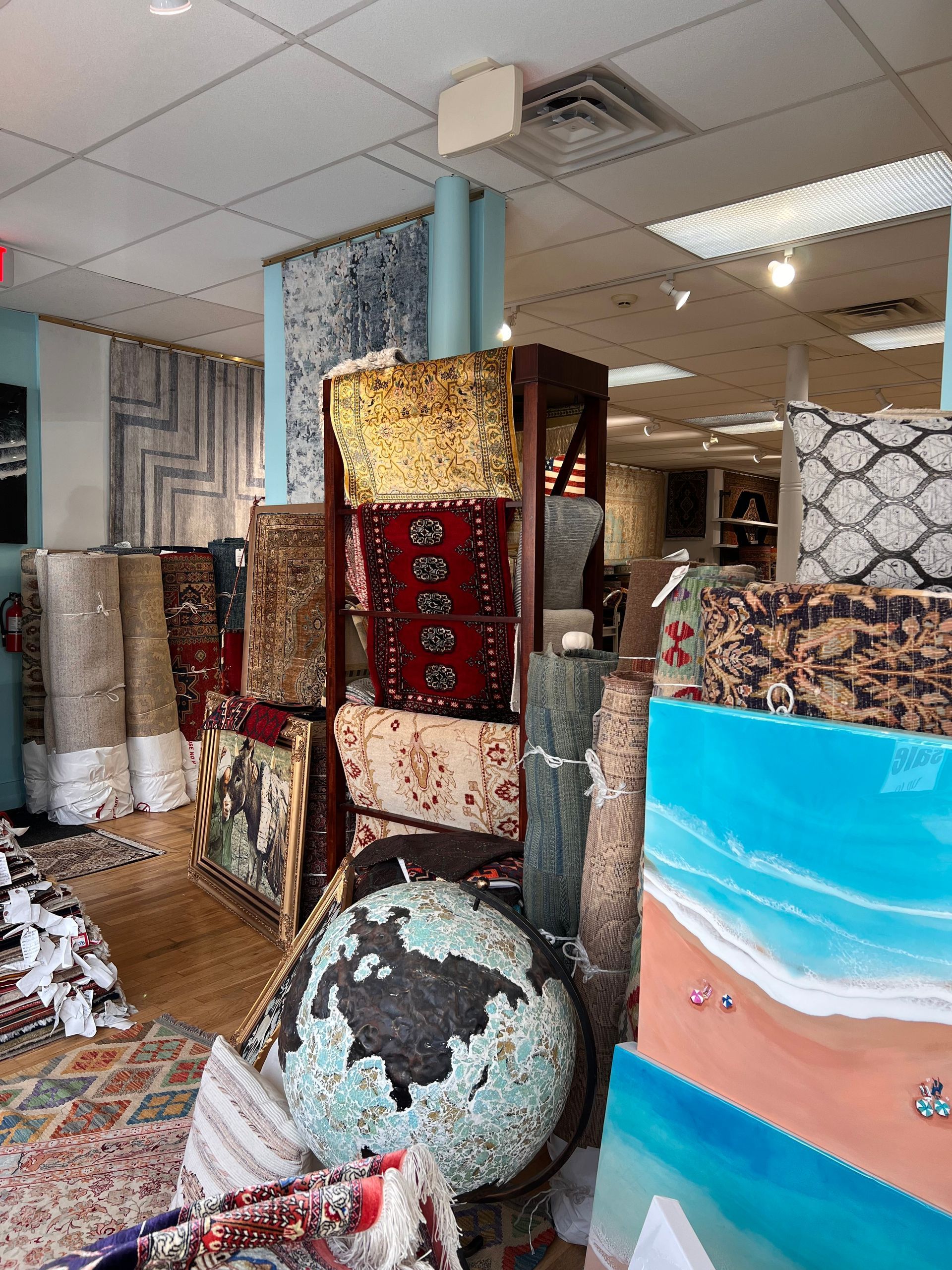 A store filled with lots of rugs and paintings.