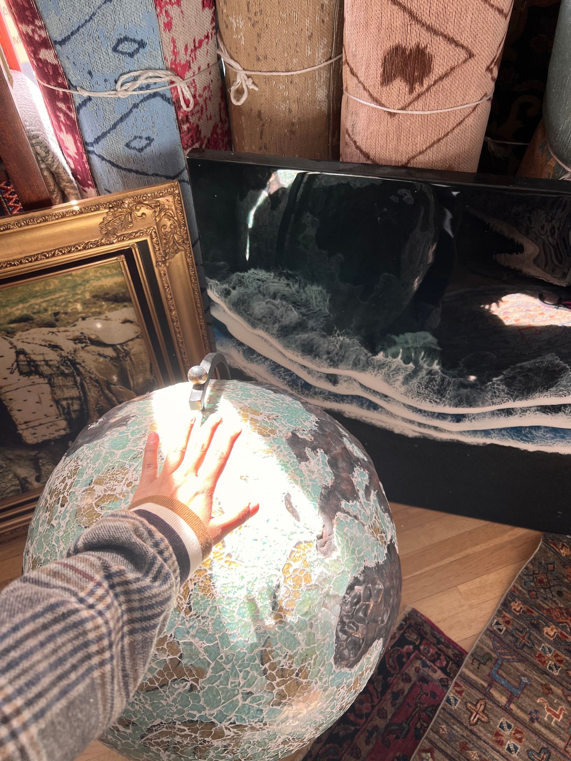 A person is holding a globe in front of a mirror.