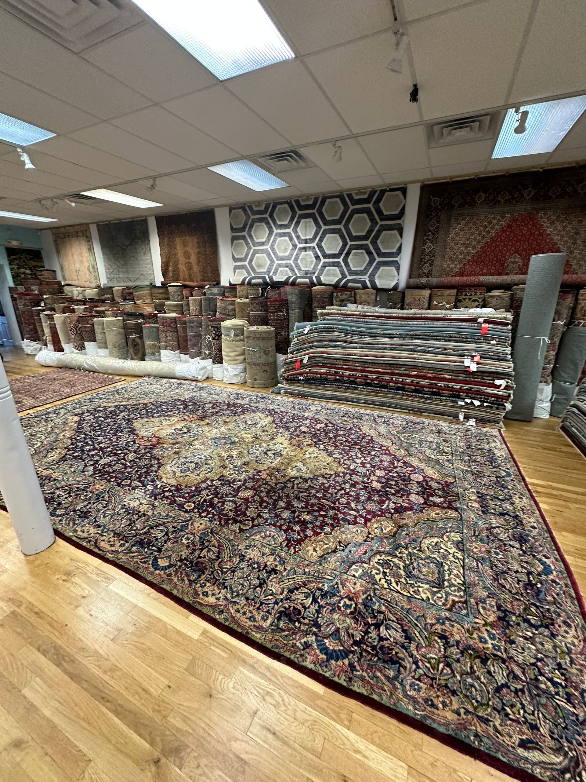 A large rug is sitting on top of a wooden floor in a store.
