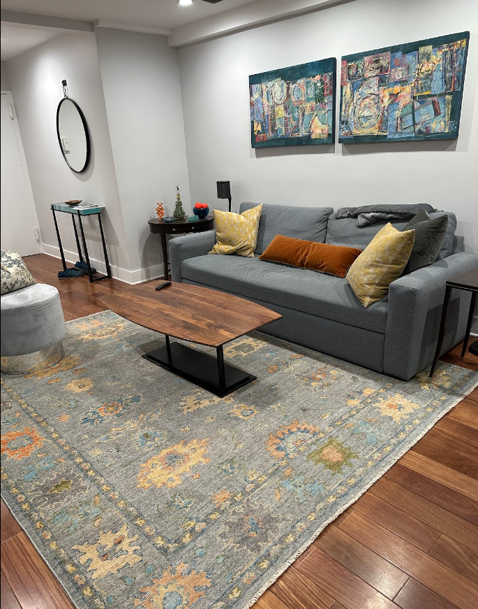 A living room with a couch , coffee table , and rug.
