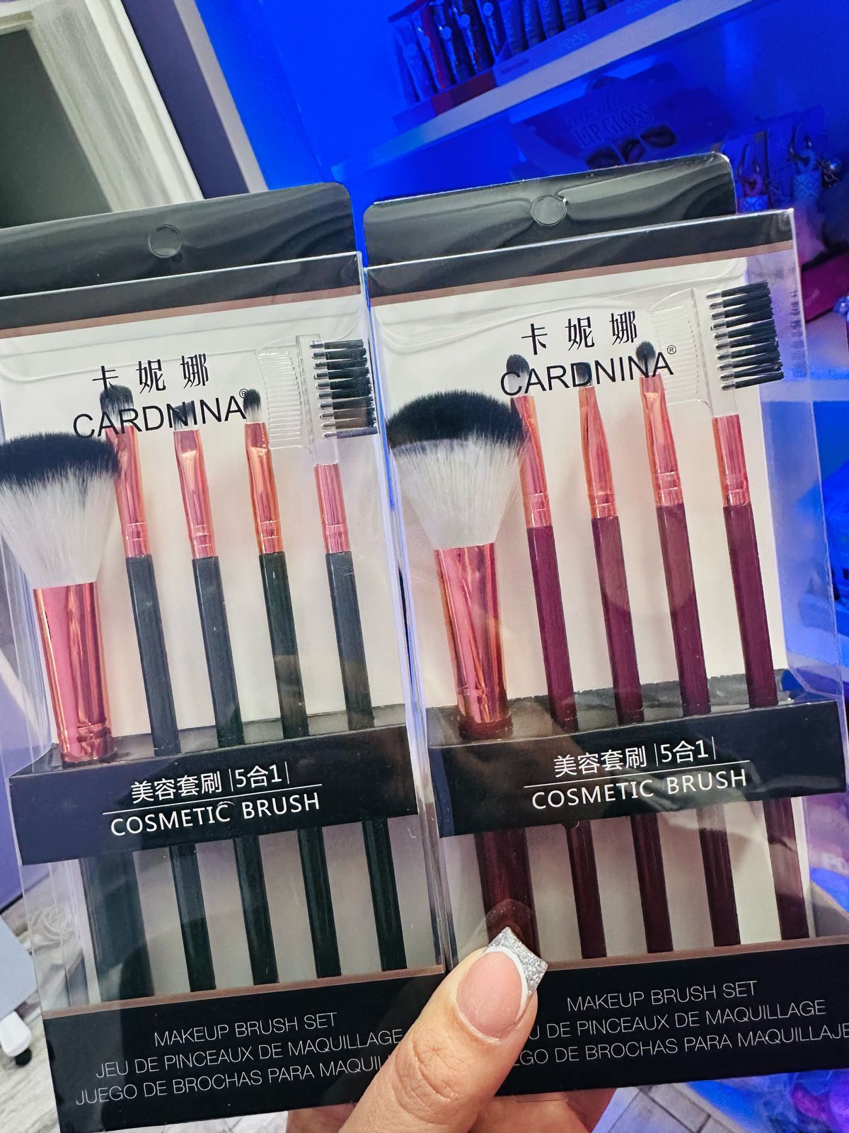 Una persona sostiene un juego de pinceles de maquillaje en su mano.