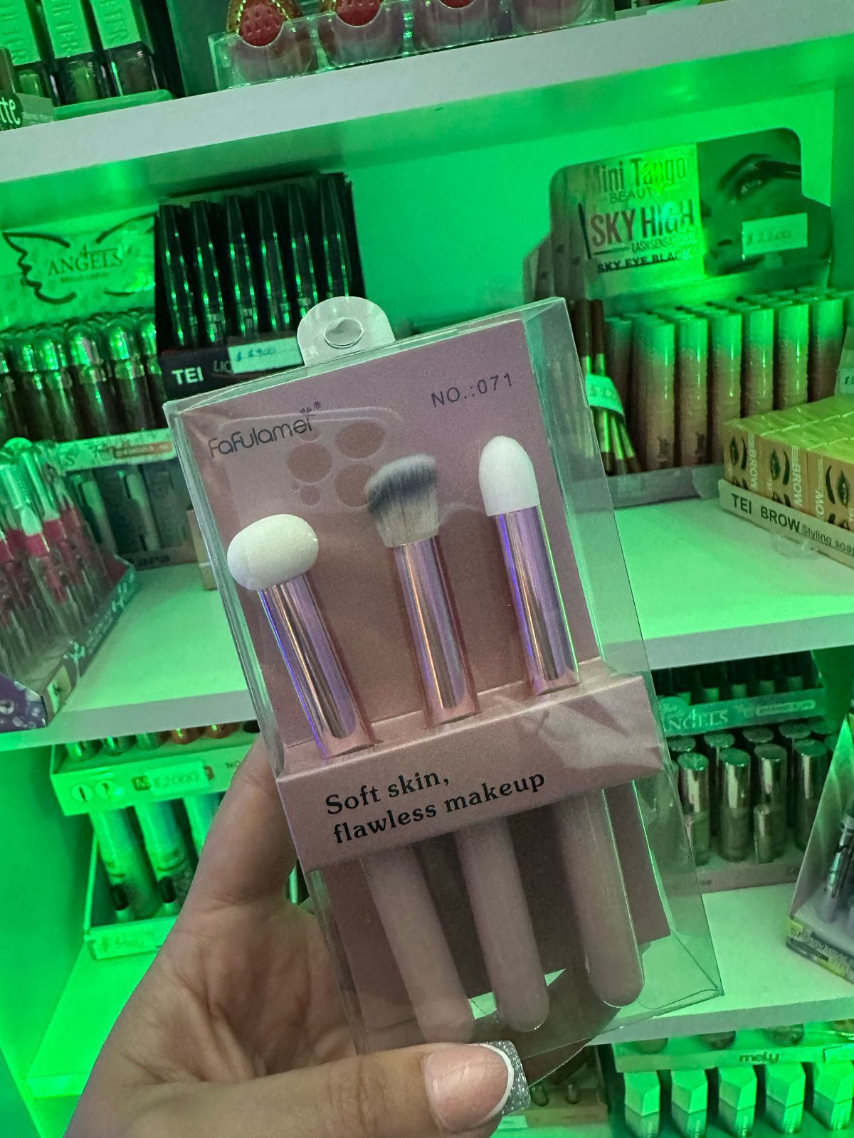 Una persona sostiene un paquete de pinceles de maquillaje en su mano.