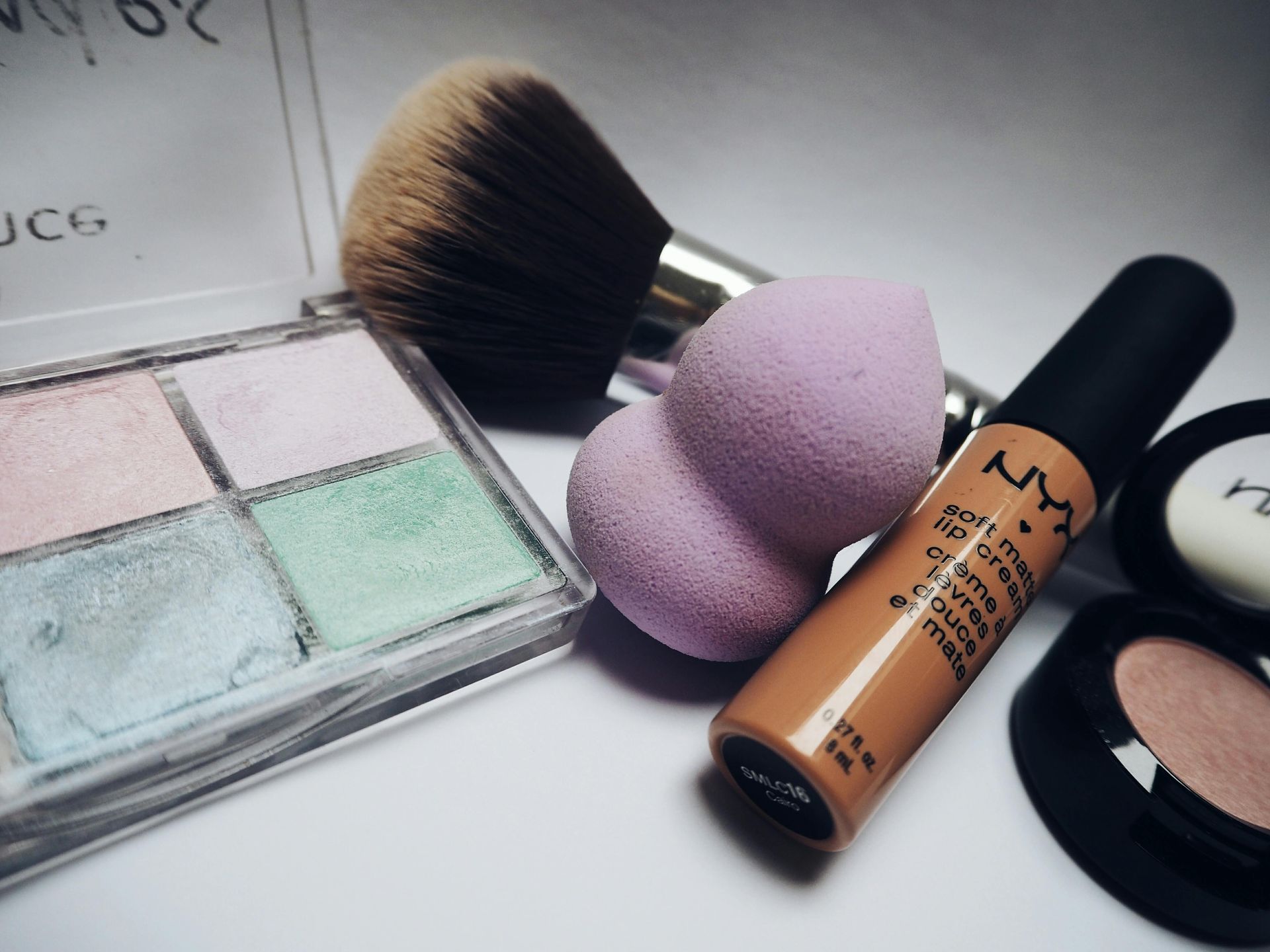 Una botella de maquillaje Nyx reposa sobre una superficie blanca.