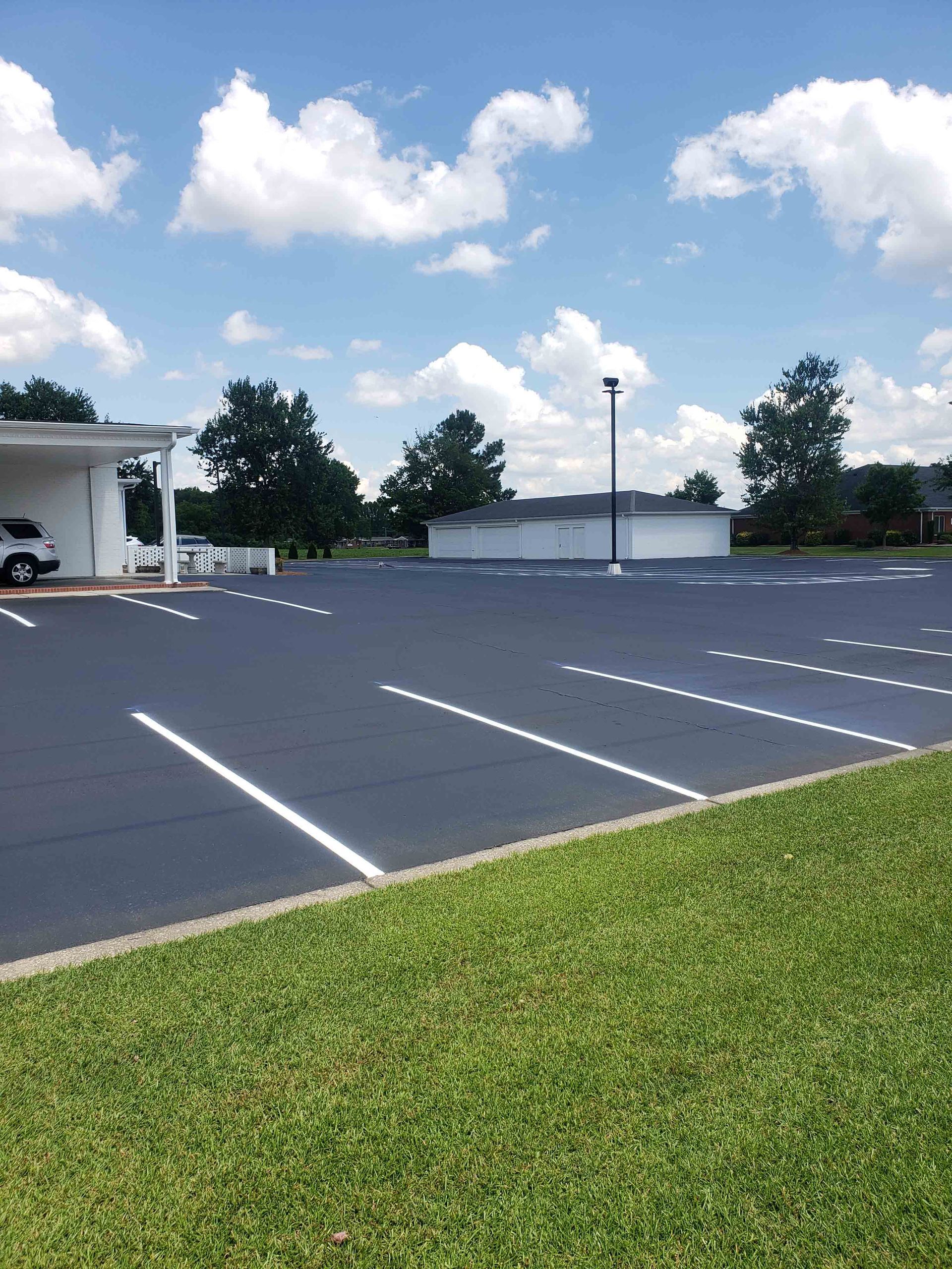 A car is parked in a parking lot in front of a building