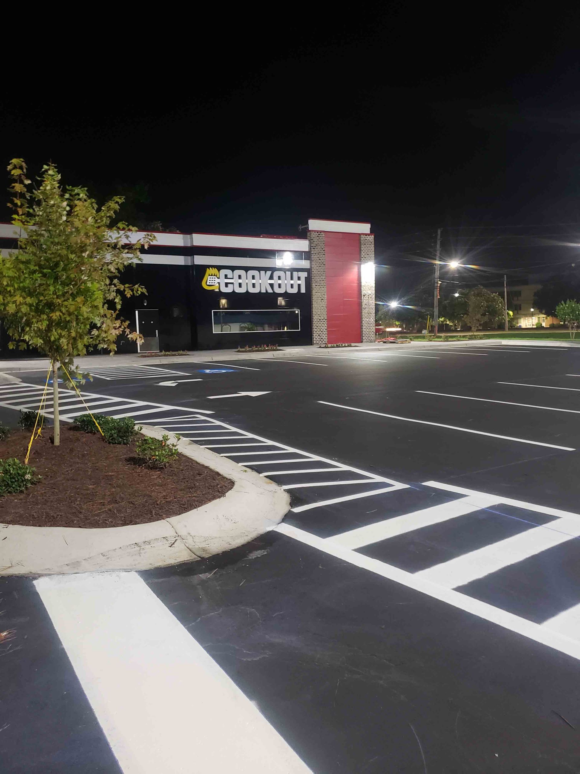 A parking lot in front of a burger king restaurant at night