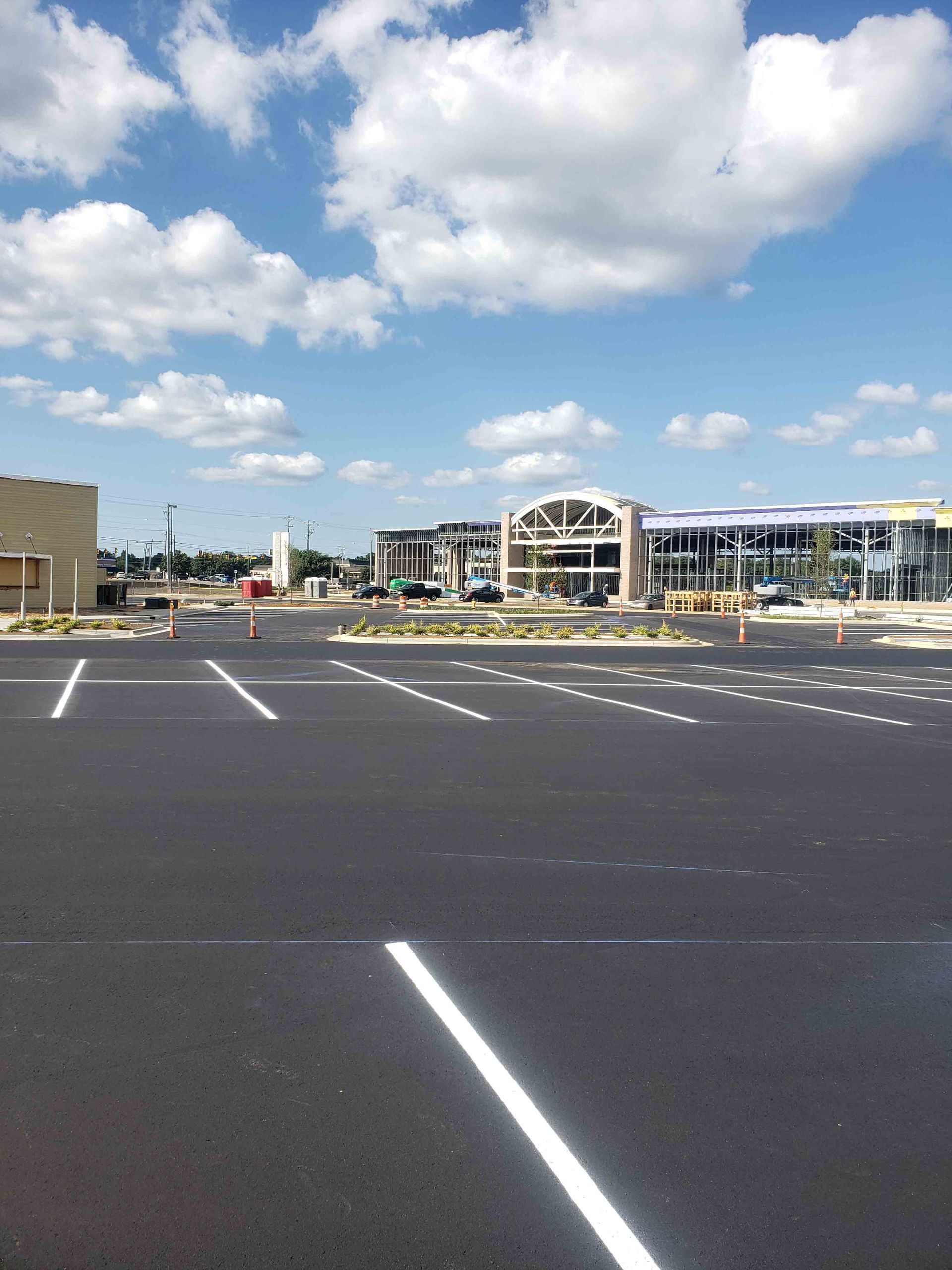 An empty parking lot with a building in the background