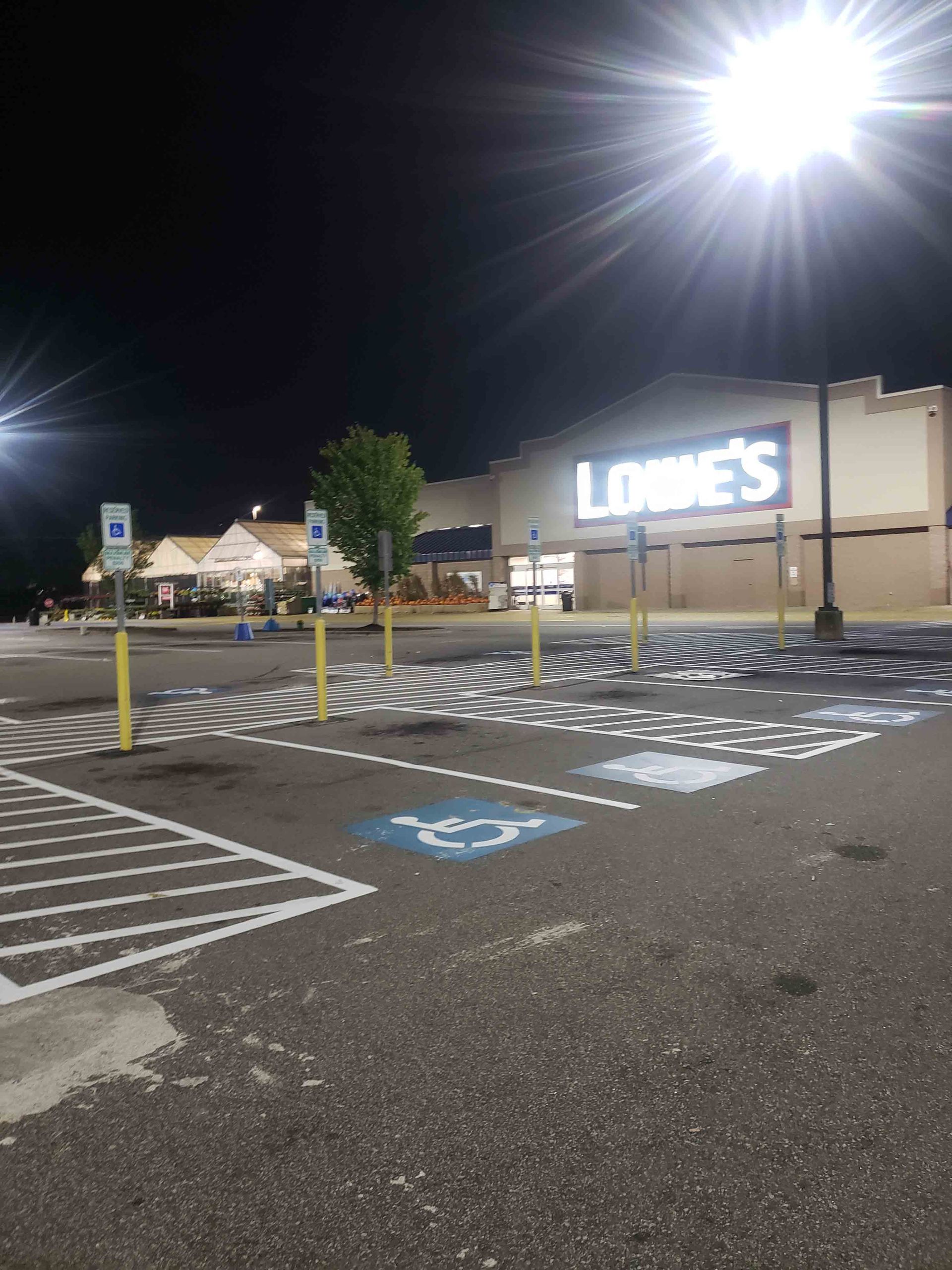 A parking lot in front of a lobbies store at night