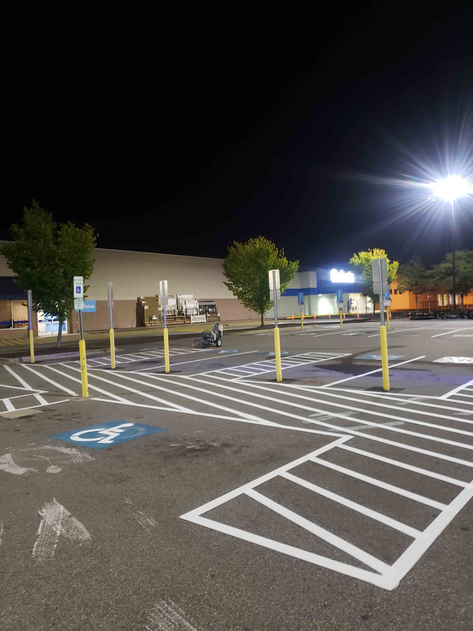 A parking lot in front of a store at night
