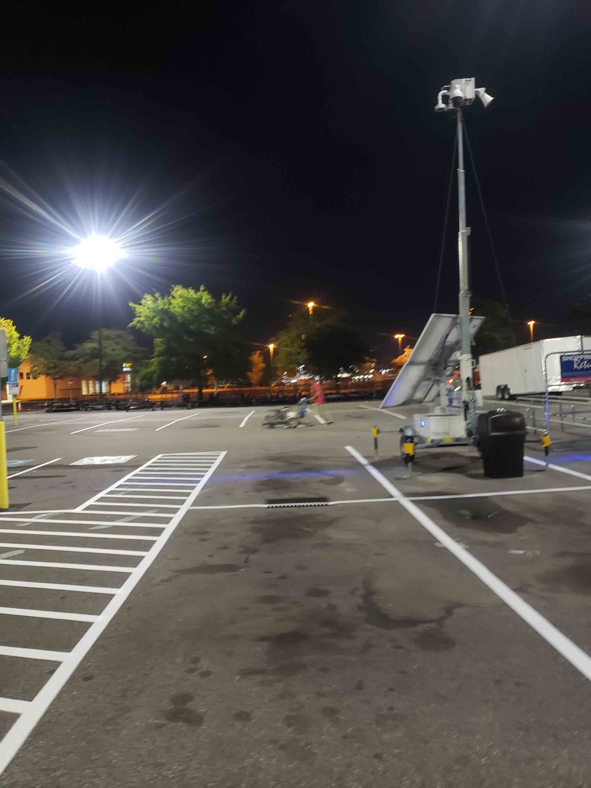 A parking lot at night with a tower in the middle