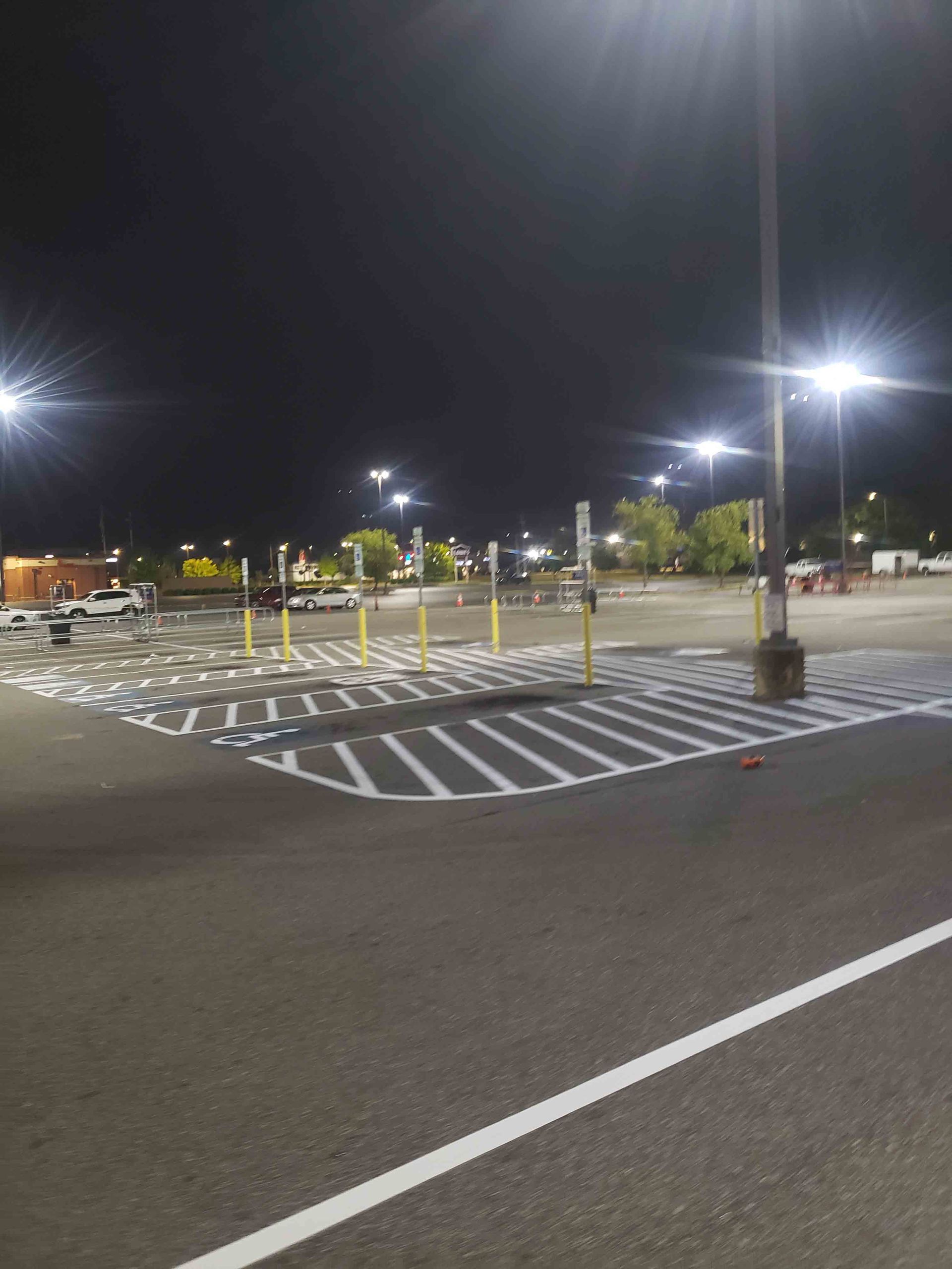 A parking lot at night with a handicapped parking spot