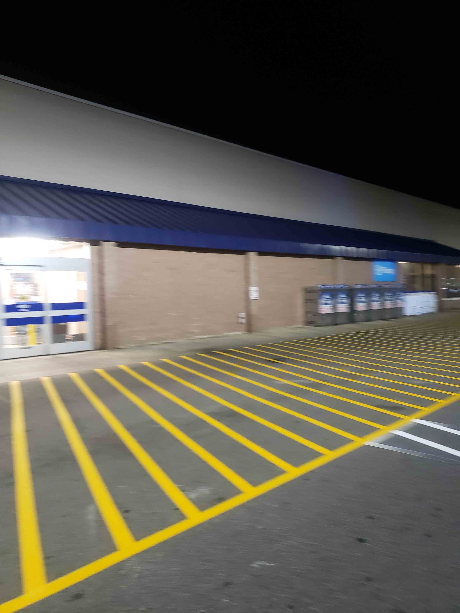 A parking lot with yellow lines in front of a store