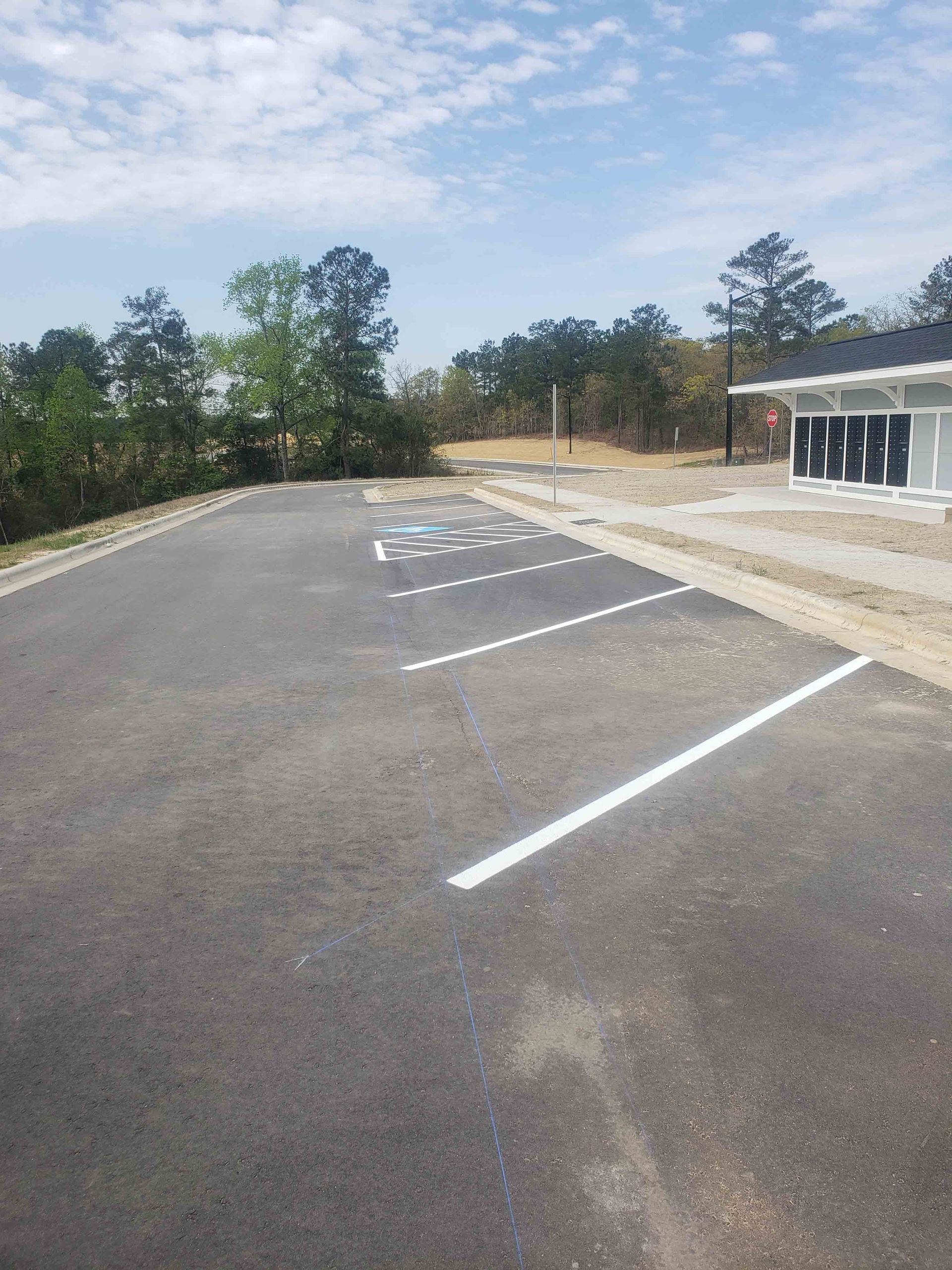 A parking lot with white lines and a building in the background